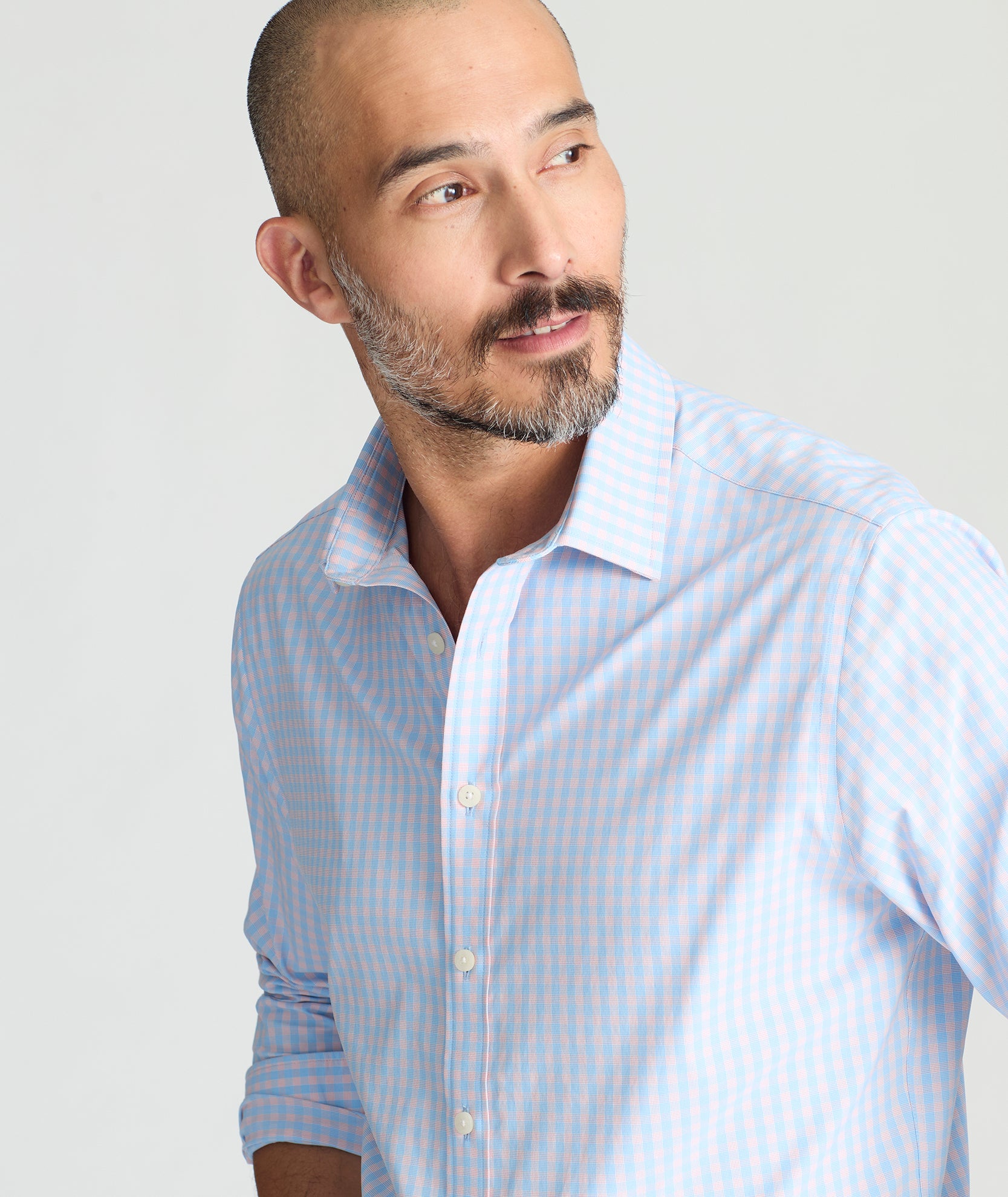 Model is wearing UNTUCKit Benson shirt in pink and blue gingham. 