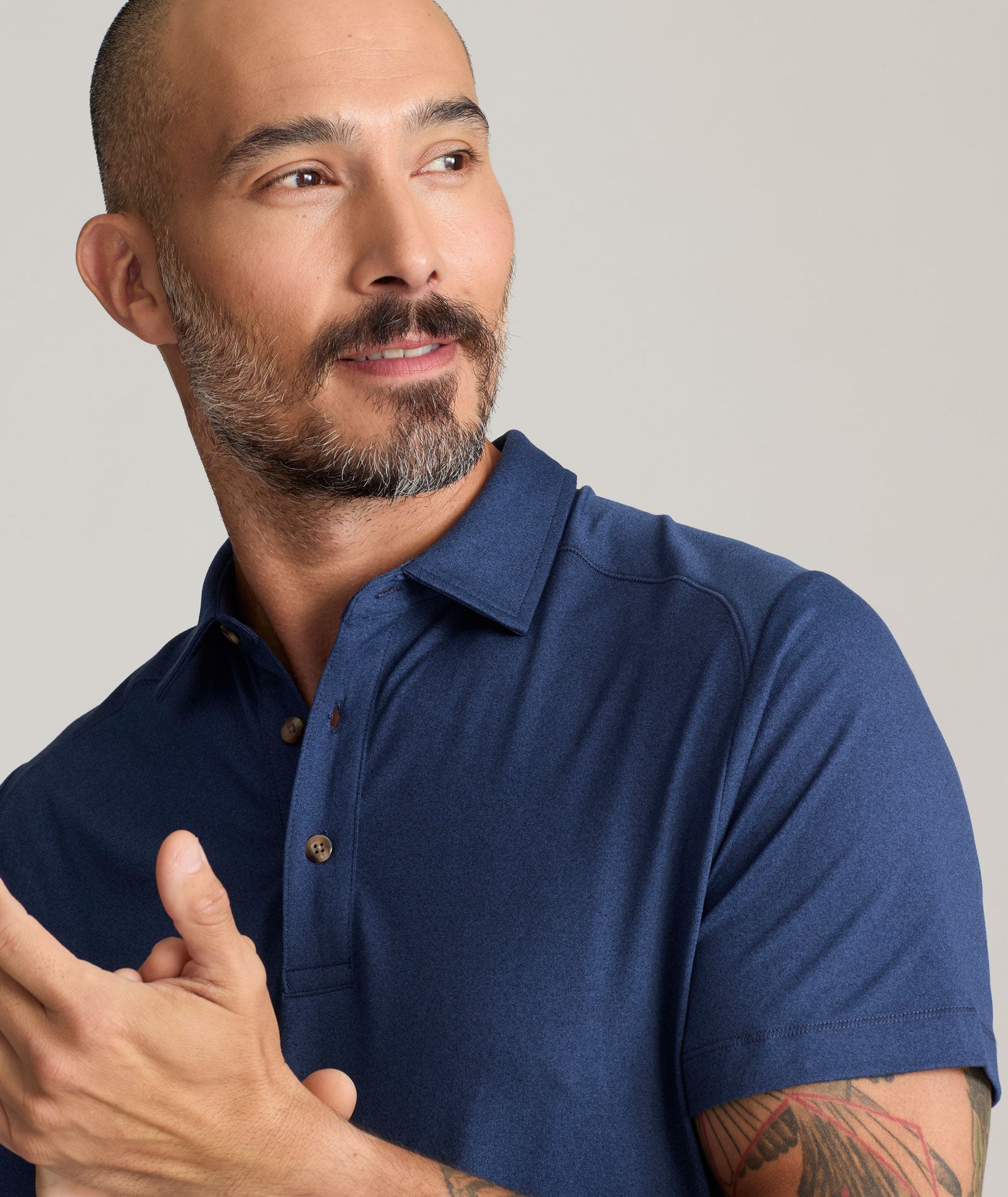 Model wearing a  Performance Polo in navy.