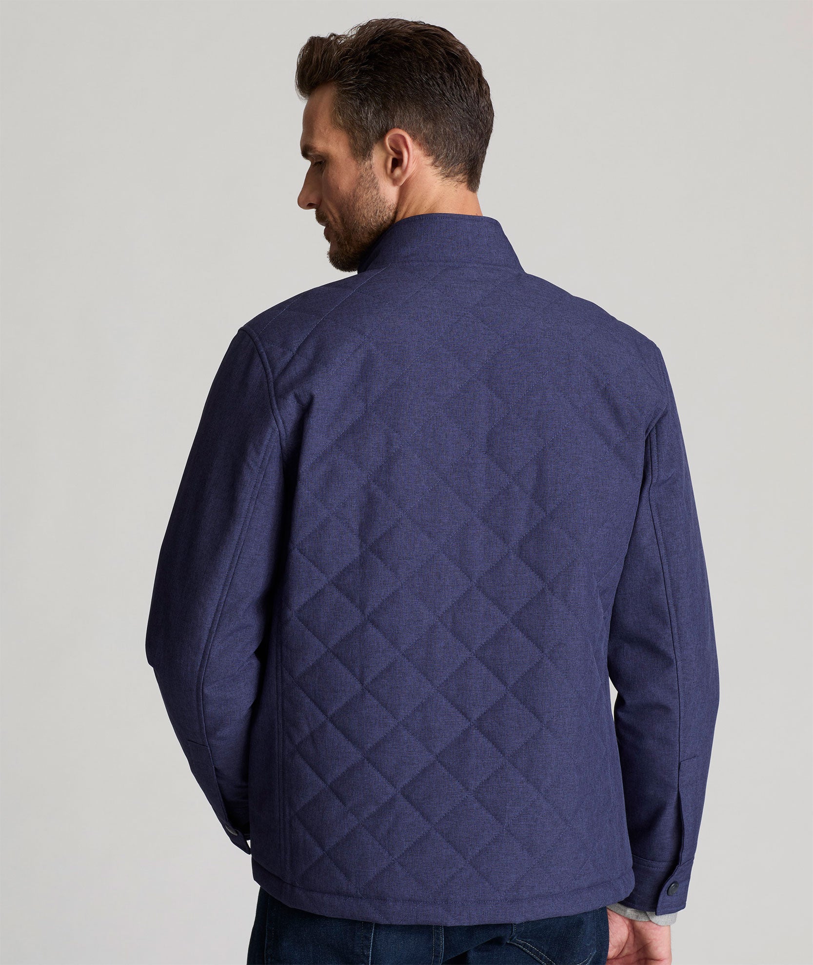 Model is wearing UNTUCKit Gardner quilted jacket in patriot blue.