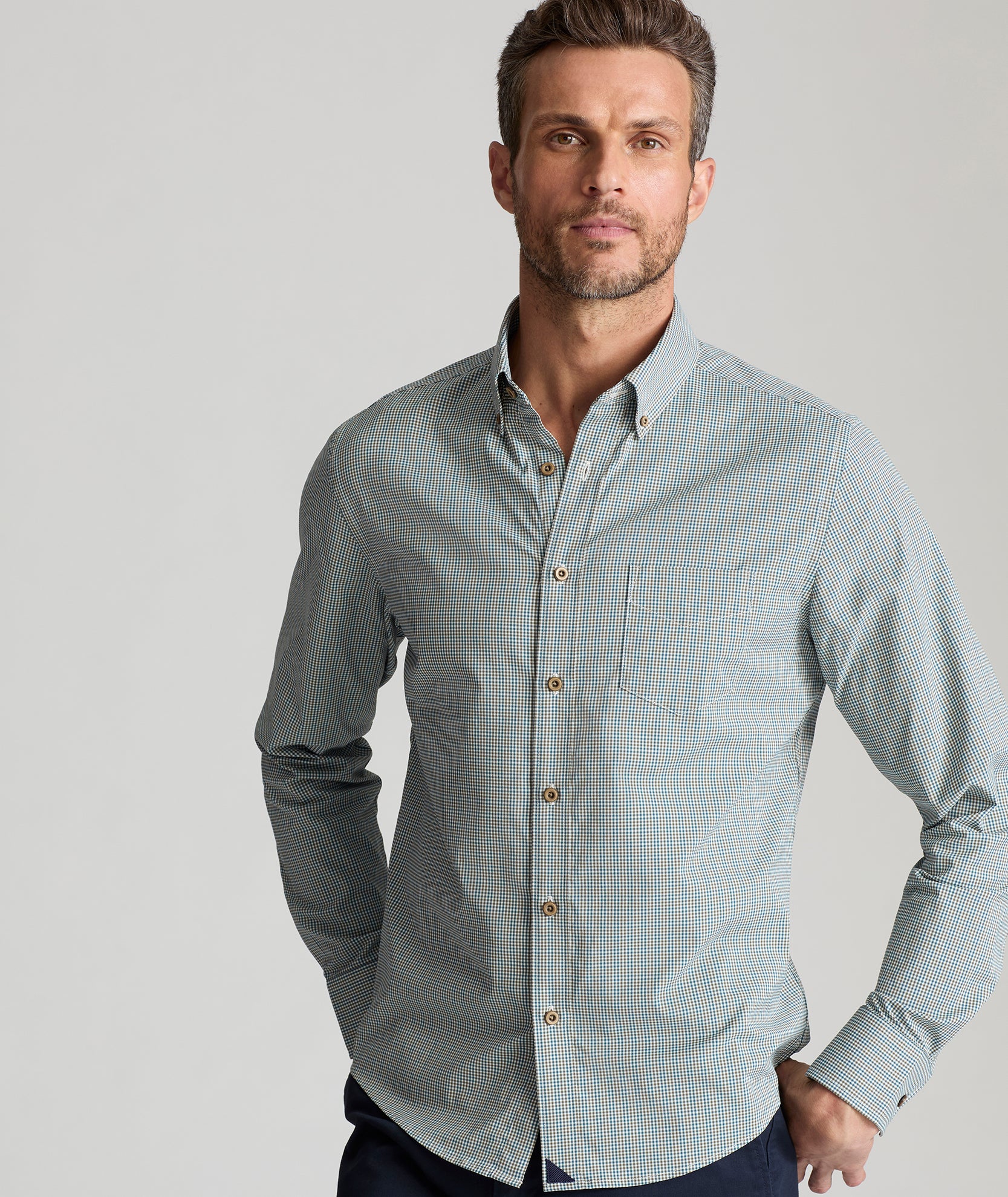 Model is wearing UNTUCKit Wrinkle-Free Performance Rowan-Brown Shirt in Small Teal & Olive Check.