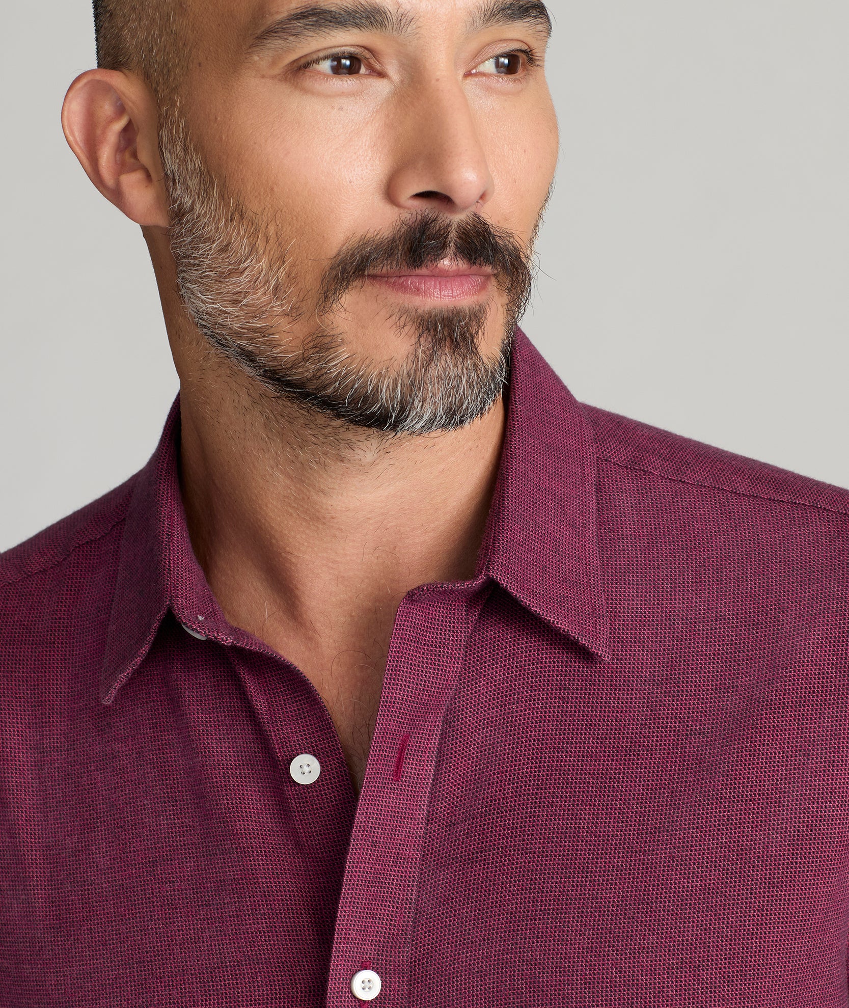 Model is wearing UNTUCKIt Wrinkle-Free Veneto Shirt in dark berry.