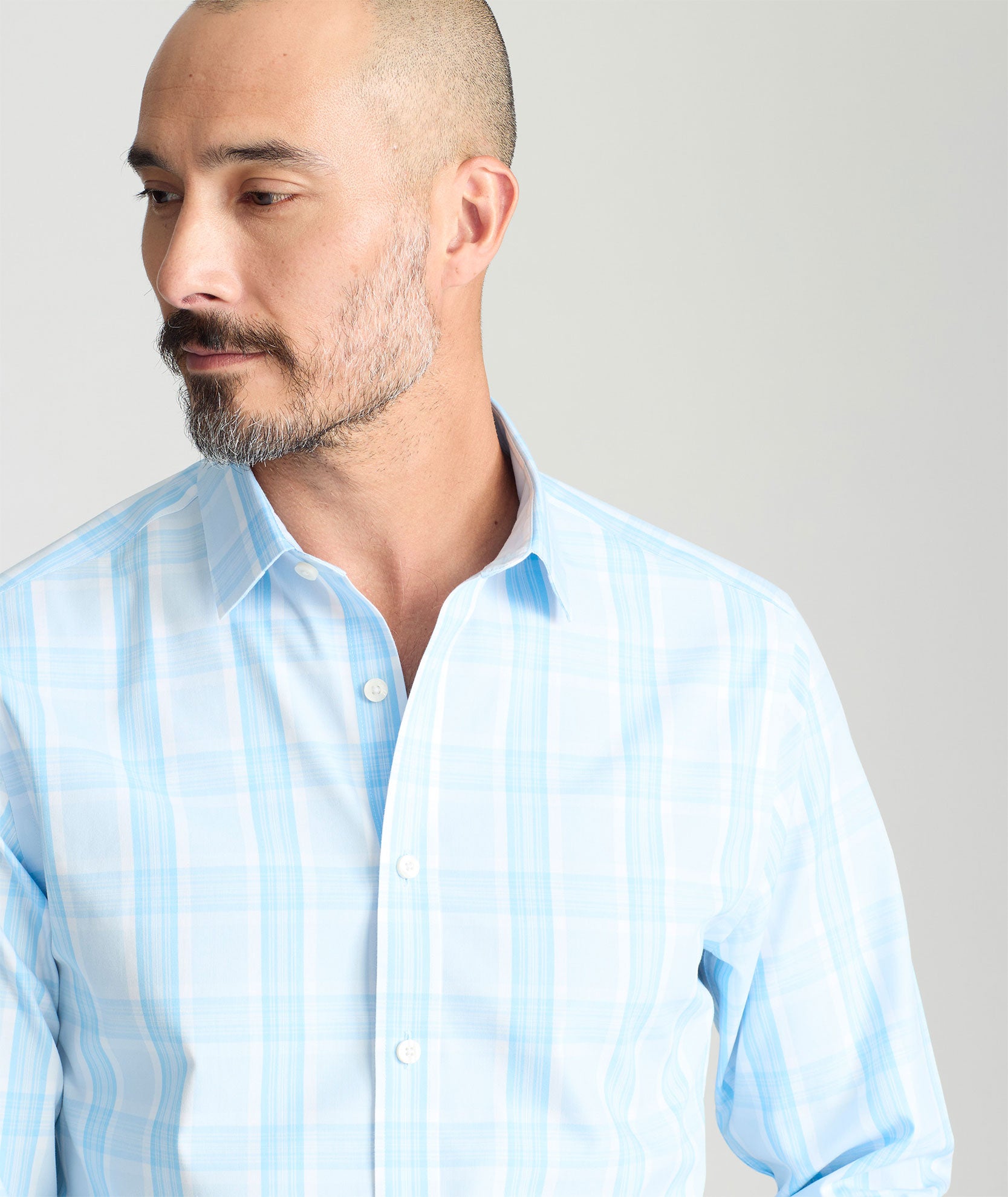 Model is wearing UNTUCKit yates wrinkle-free shirt in light blue large plaid. 