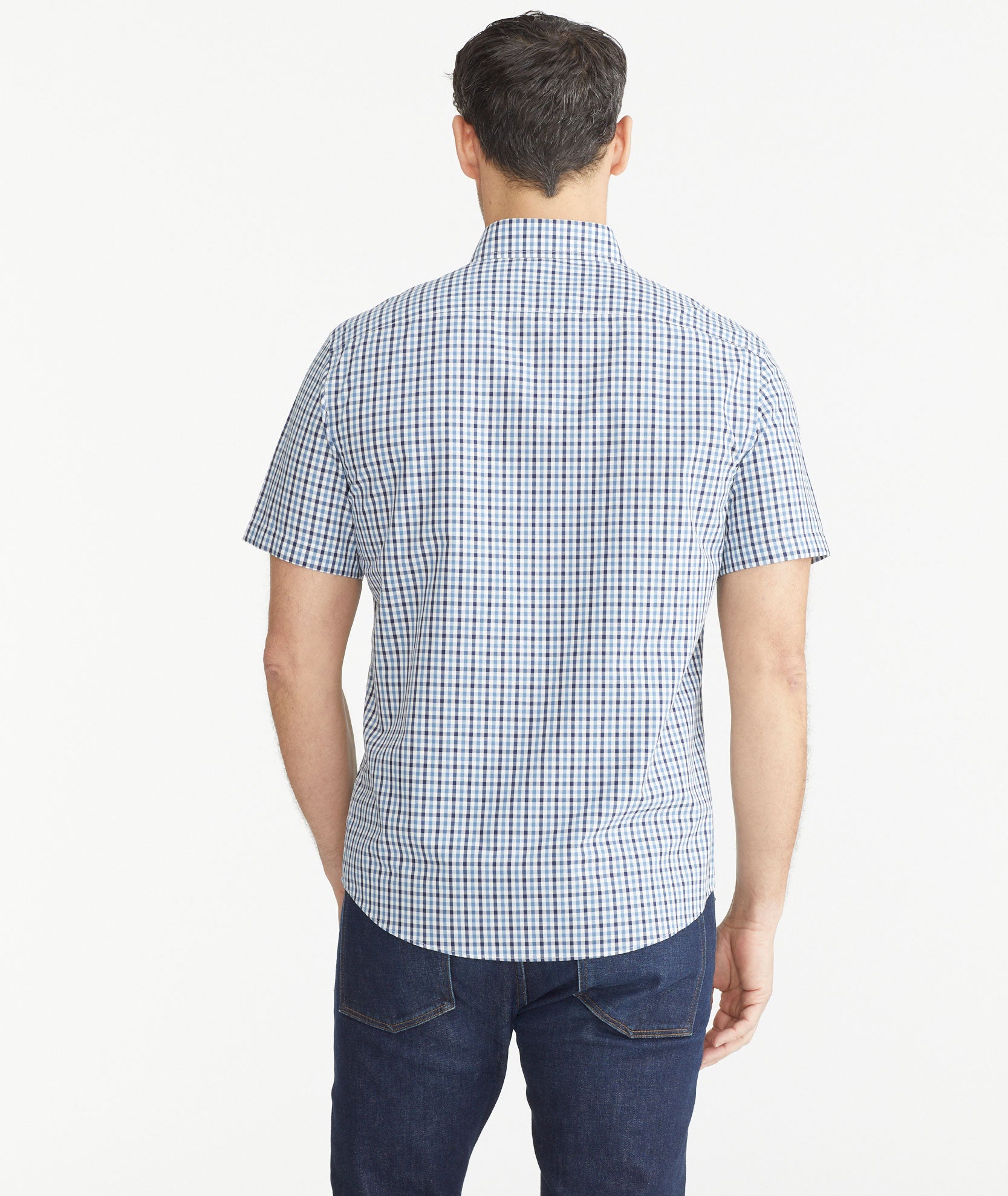 Model is wearing UNTUCKit Teal & Navy Check Wrinkle-Free Short-Sleeve Melvald Shirt.