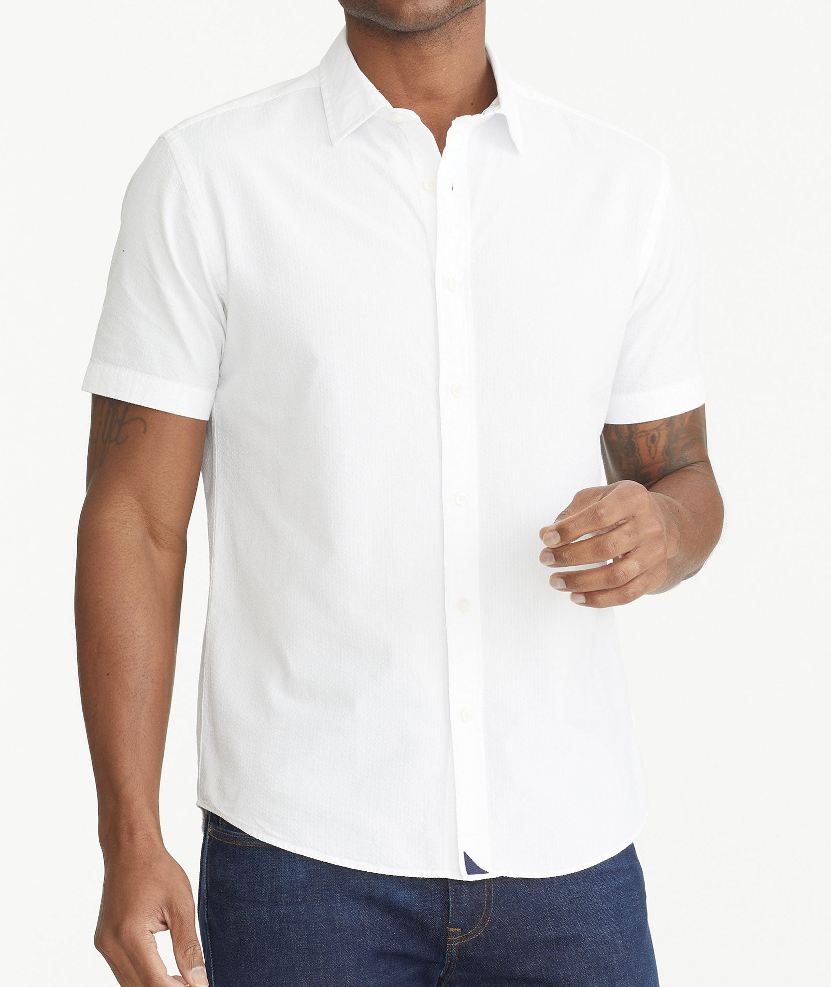 Model is wearing UNTUCKit White Cotton Seersucker Short-Sleeve Pavao Shirt.